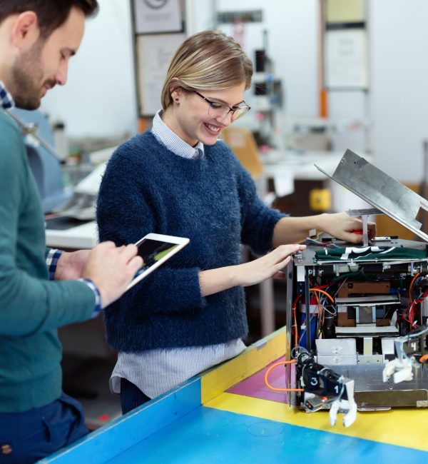 Young students of robotics preparing robot for testing